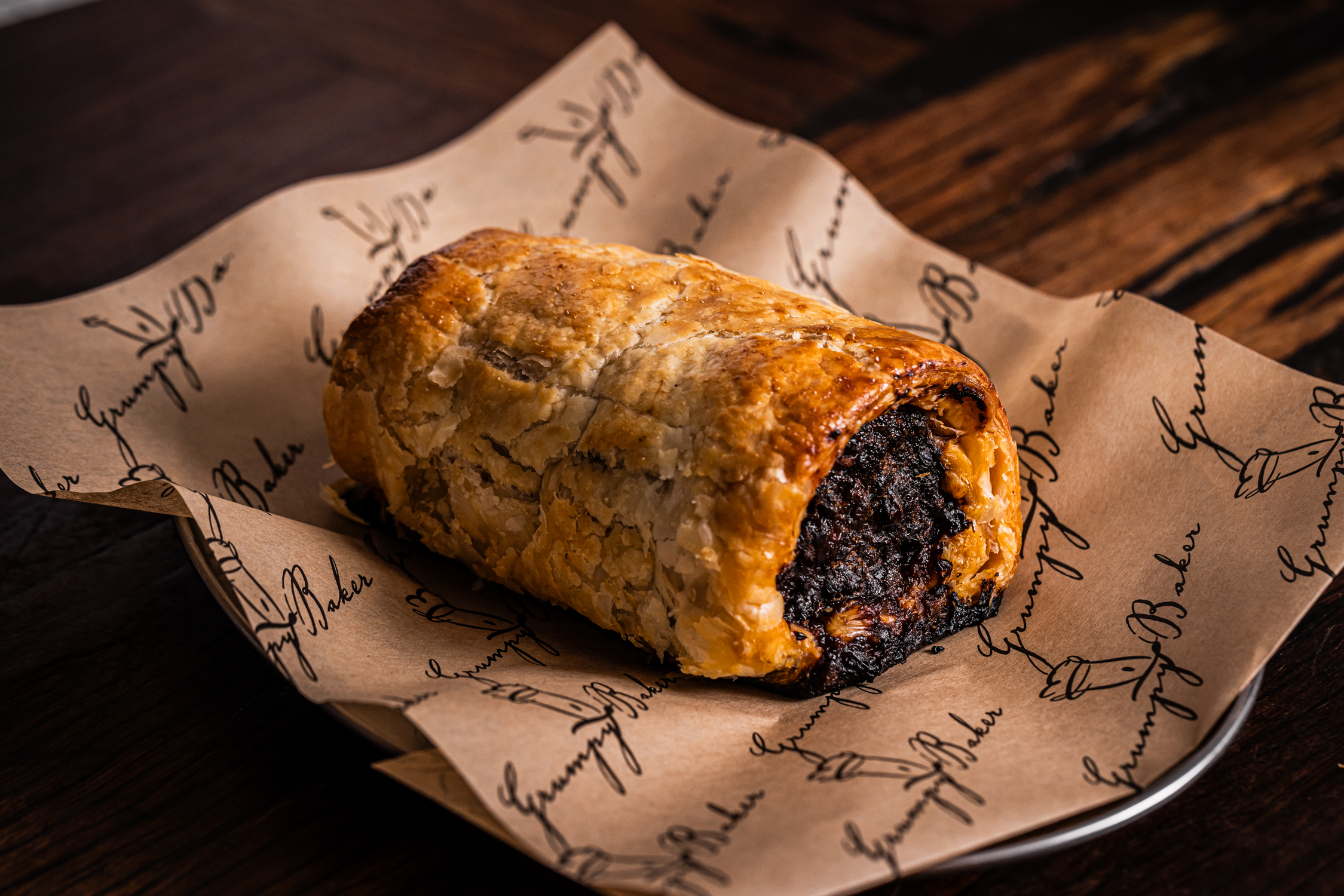 Crispy beef sausage roll on grumpy baker themed baking paper